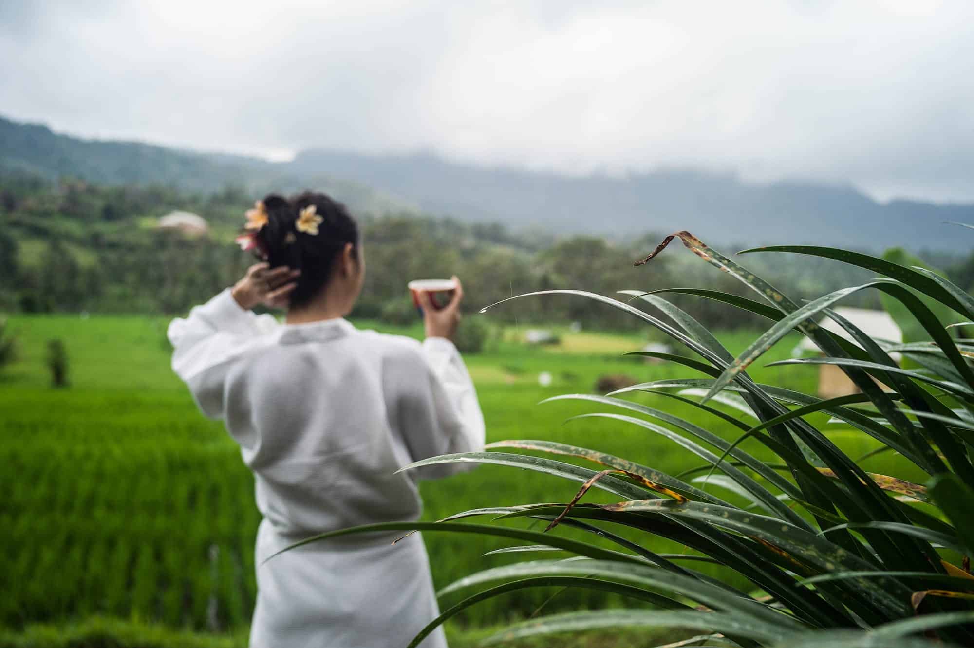 Frau genießt eine Tasse Tee mit Blick auf die Reisfelder - Villa Uma Dewi Sri - Bali - Sidemen